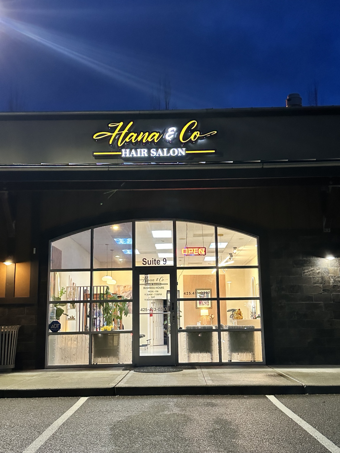 Hana and Co Hair Salon storefront at night